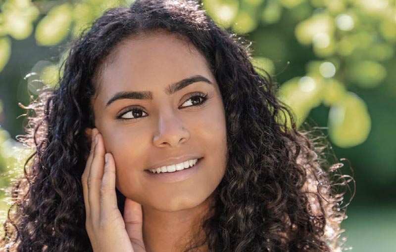 woman smiles with clear skin after acne treatment