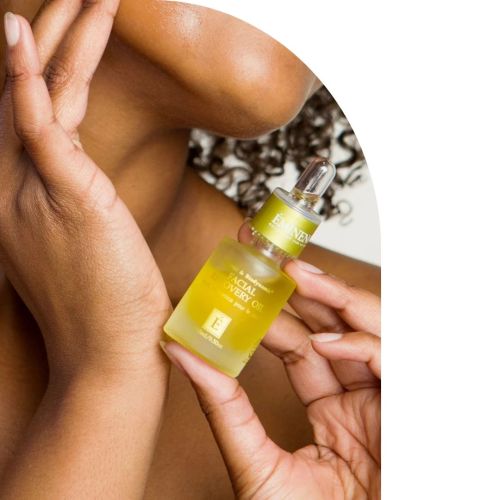 closeup of woman applyig Eminence Facial Recovery Oil